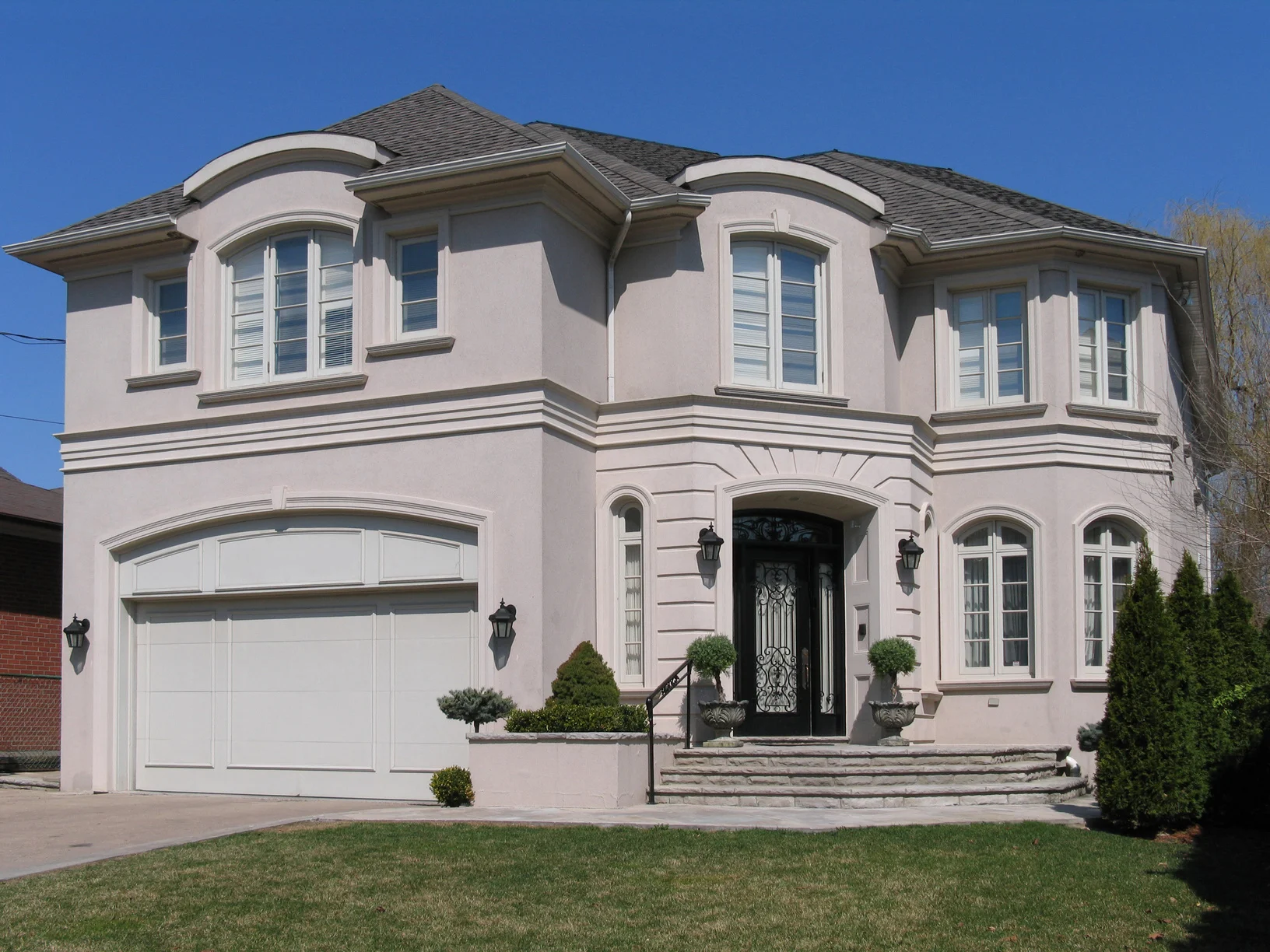 House with stucco walls and dark grey roofing